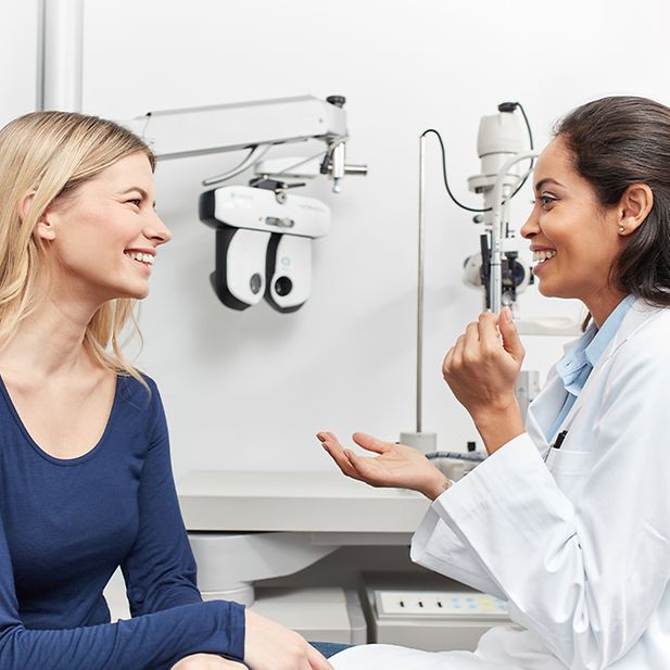 Optician helping patient during eye exam