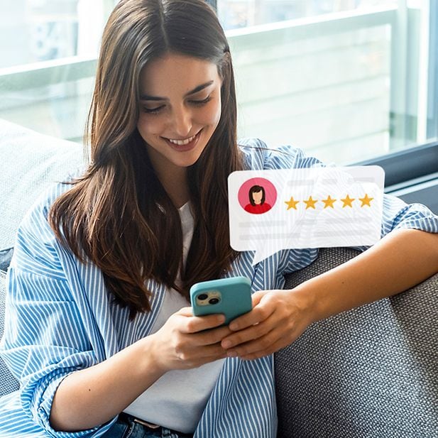 Une personne lit en souriant les avis Trustpilot de Vision Direct publiés par d’autres clients. 